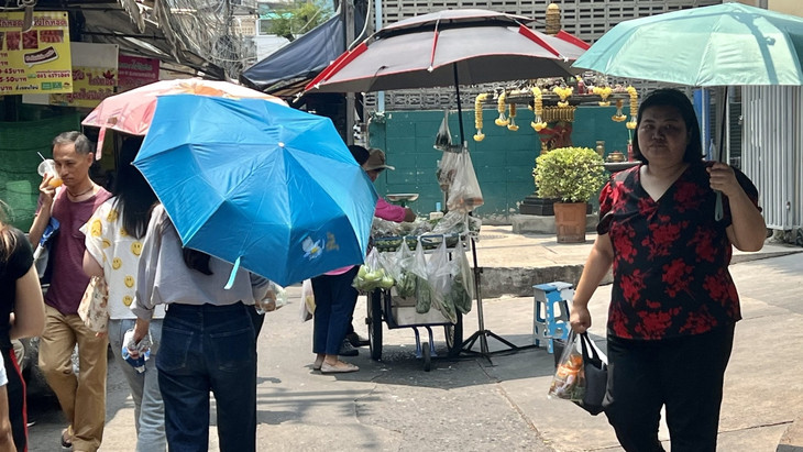 Vergangenen April schützen sich Menschen in Bangkok mit Schirmen vor der extremen Hitze und vor der Sonne.