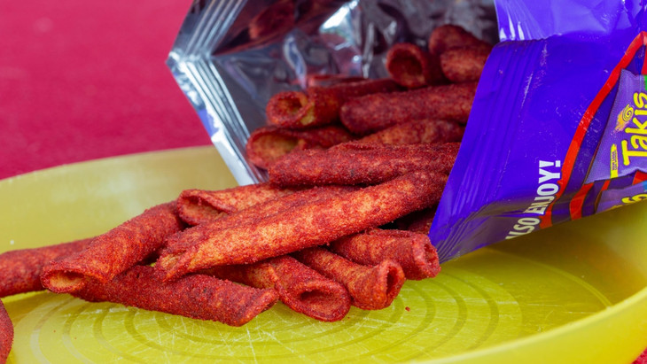 Eine geöffnete Tüte Takis-Chips liegt auf dem Tisch.