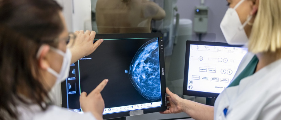 Medizinisches Personal untersucht bei einem Mammographie-Screening die Brust einer Frau auf Brustkrebs.