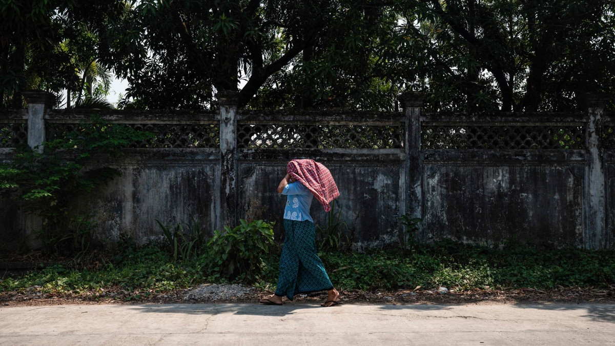 Eine Frau versucht sich vor der Hitze in den Straßen Yangons in Myanmar zu schützen.