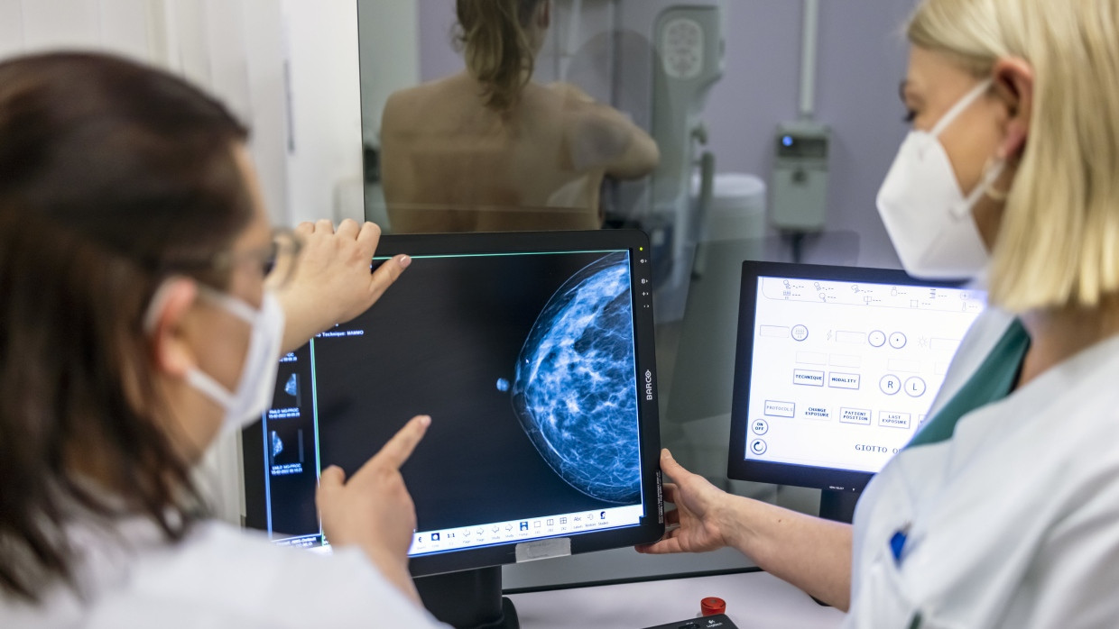 Medizinisches Personal untersucht bei einem Mammographie-Screening die Brust einer Frau auf Brustkrebs.