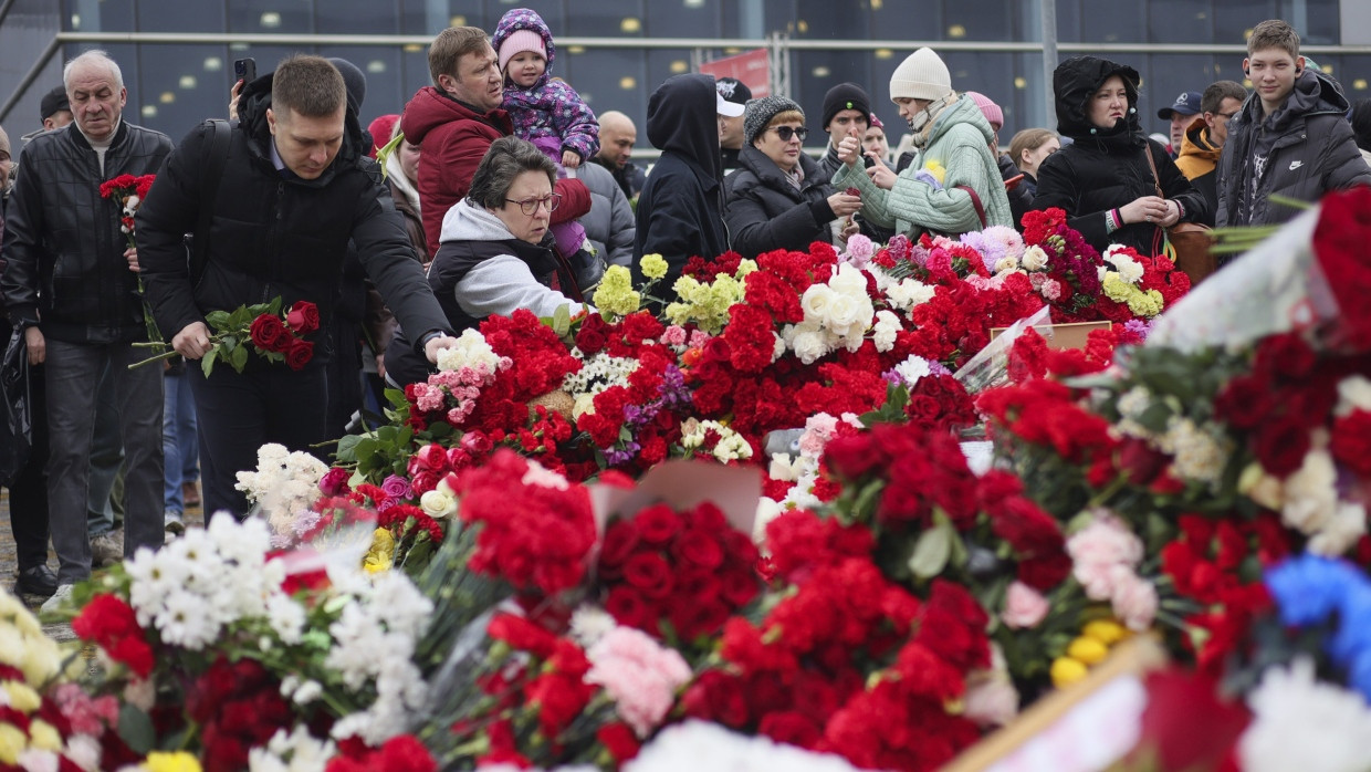 Bürger legen am Sonntag am Zaun neben der überfallenen Konzerthalle „Crocus City Hall“ Blumen nieder