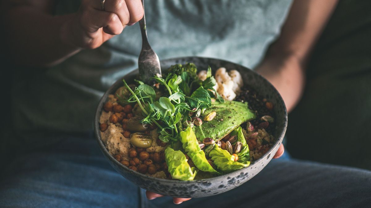 Woman eating healthy vegan dish from bowl