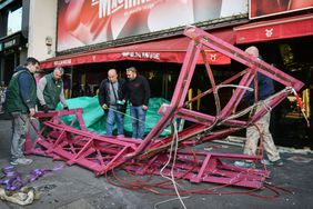 Workers remove the wings of the Moulin Rouge cabaret in Paris on April 25, 2024, after it collapsed last evening.