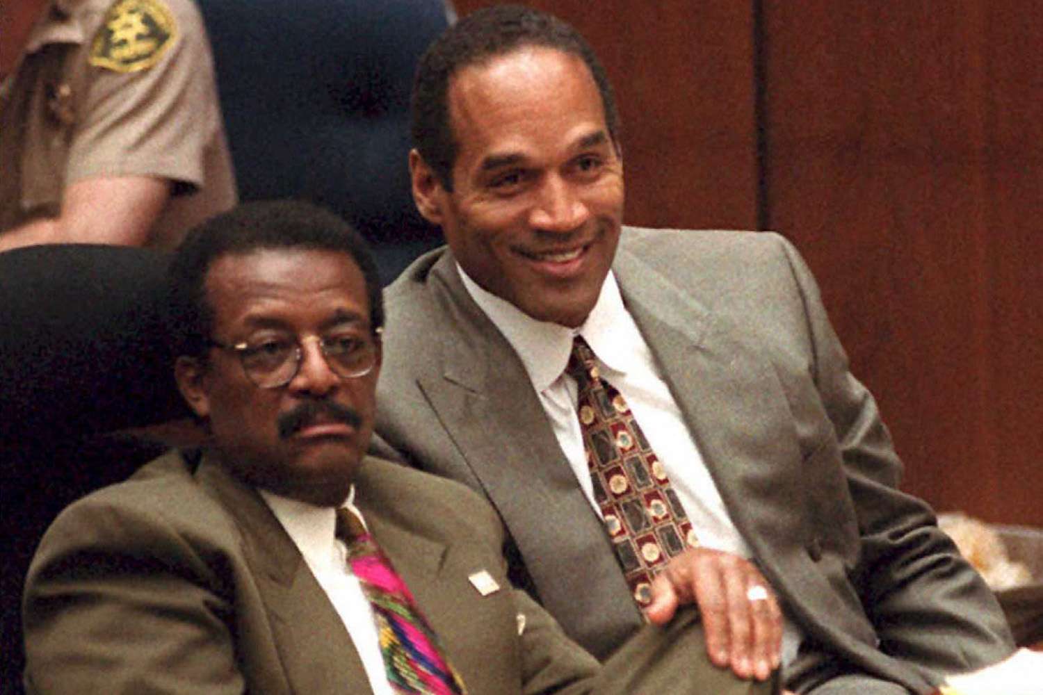 OJ Simpson (R), seated next to his lawyer Johnnie Cochran Jr., laughs as Brian "Kato" Kaelin testifies about the acting jobs he has received since the night of the murders 22 March during the OJ Simpson murder trial. 