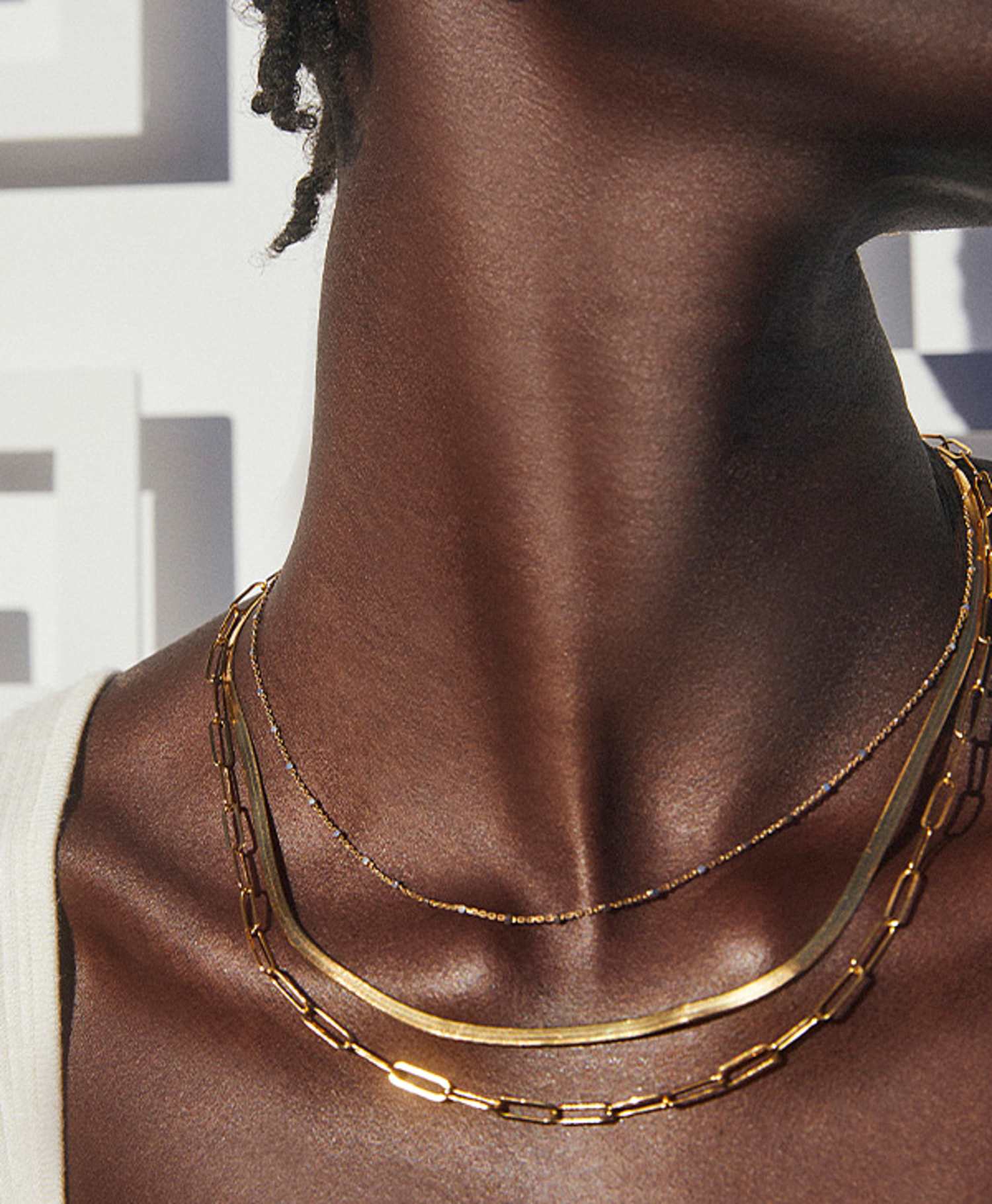 Image of model wearing multiple necklaces