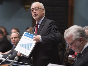 Quebec Finance Minister Carlos Leitao responds to Opposition questions over the budget speech, during question period Wednesday, March 29, 2017 at the legislature in Quebec City. Quebec Premier Philippe Couillard, right, looks down.