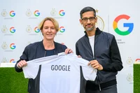 Bundestrainerin Martina Voss-Tecklenburg (links) übergibt Google-CEO Sundar Pichai ein DFB-Nationaltrikot mit der Rückenaufschrift „Google“.